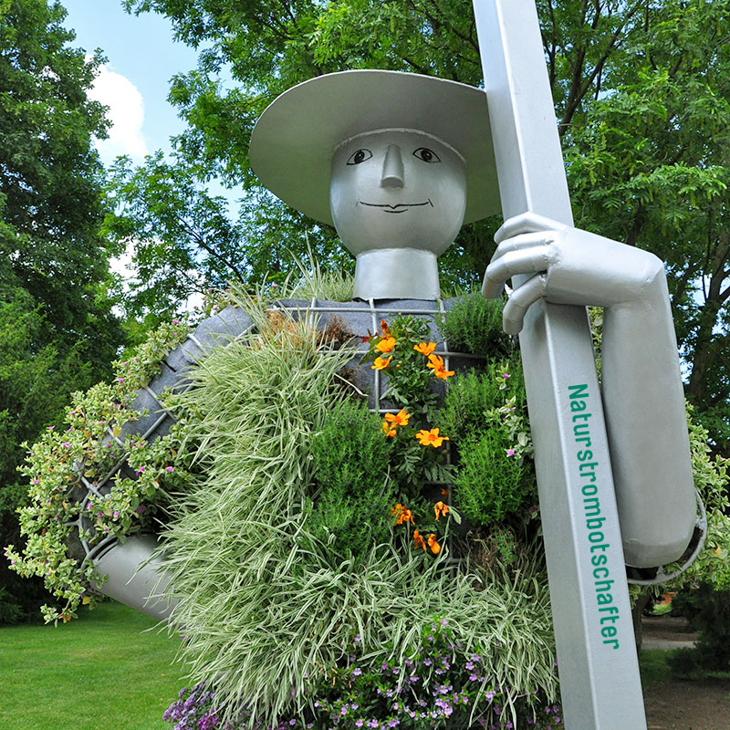 Bepflanzte Metallstatue mit Gesicht und Hut